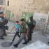 Two Palestinian boys are taken by Israeli Border Police officers to the Israeli settler boy and his father