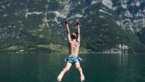 Jonas jumps into the water of the Walensee lake near Murg, Switzerland, Saturday, Aug. 27, 2016. (Gian ...