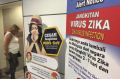 A traveller walks past a travel advisory on the Zika virus infection in Kuala Lumpur International Airport.