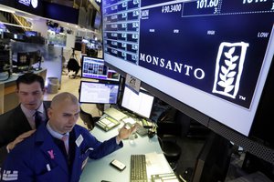 Specialists John McNierney, left, and Philip Finale work at the post that handles Monsanto on the floor of the New York Stock Exchange