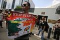 A protester holds a poster during a rally outside the Australian Embassy in Jakarta to  show  support for  Timor Leste ...