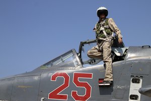 In this photo taken on Saturday, Oct. 3, 2015, Russian army pilot poses at a cockpit of SU-25M jet fighter at Hmeimim airbase in Syria. Russia has insisted that the airstrikes that began Wednesday are targeting the Islamic State group and al-Qaida's Syrian affiliates, but at least some of the strikes appear to have hit Western-backed rebel factions.