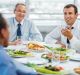 Lunch break. Group of successful businesspeople sitting and eating.  