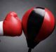 Punching a red punch bag concept for competition, challenge, conflict or leadership in business