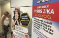 A traveller walks past a travel advisory on the Zika virus infection in Kuala Lumpur International Airport.