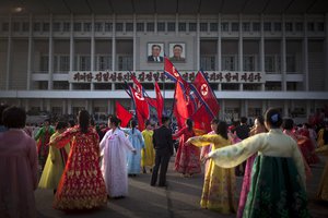 A man, center, supervises a dancing group  during a mass folk dance in front of the Pyongyang Indoor Stadium to celebrate the 101st birthday of the late leader Kim Il Sung in Pyongyang, North Korea