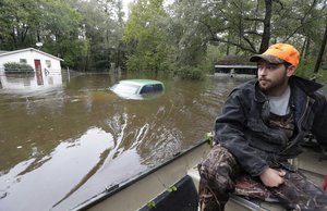 Hunter Baker surveys flood damage to his neighborhood near the flooded Black Creek following heavy rains in Florence, South Carolina, Monday, Oct. 5, 2015.