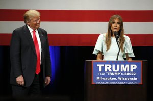 Republican presidential candidate, Donald Trump, left, listens to his wife Melania as she addresses the crowd during a rally at the Milwaukee Theatre Monday, April 4, 2016, in Milwaukee.