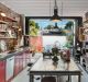 49 Gowrie Street, Newtown: The open-plan kitchen sports glossy red door fronts within steel frames and lots of open shelving.