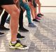 Cropped shot of young athletes at start position. Fit young people preparing for race along sea. Focus on legs of runners.