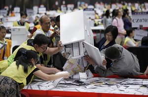 Electoral officers count ballots at the central ballot counting station for the legislative council elections in Hong Kong, Monday, Sept. 5, 2016.