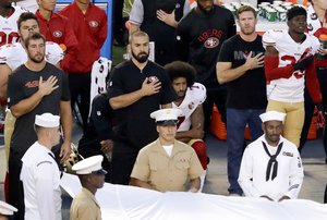 San Francisco 49ers quarterback Colin Kaepernick, middle, kneels during the national anthem before the team's NFL preseason football game against the San Diego Chargers, Thursday, Sept. 1, 2016, in San Diego.