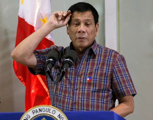 In this Aug. 31, 2016, file photo, Philippine President Rodrigo Duterte gestures as he addresses Overseas Filipino Workers who were repatriated back to the country at the Ninoy Aquino International Airport in Pasay city, south of Manila, Philippines.