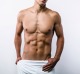 Studio portrait of sexy sporty young man. Muscular man with naked torso and towel on hips