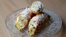 Cannoli stuffed with ricotta and dipped in pistachio is a Sicilian dessert staple.