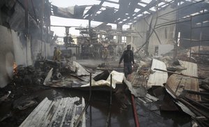 File - Firefighters work to extinguish fire at a food factory hit by Saudi-led airstrikes in Sanaa, Yemen, Tuesday, Aug. 9, 2016.