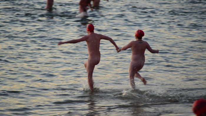 Nude swim: Hundreds brave the cold to skinny dip in Hobart's River Derwent for winter solstice