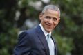 President Barack Obama smiles as he walks across the South Lawn of the White House.