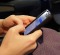 A passenger checks her cell phone before a flight.