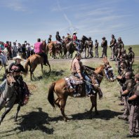 Lakota riders from the Rosebud, Standing Rock and Lower Brule Reservations stood against a police line in a peaceful demonstration this month as part of a traditional ceremony to introduce horses. Credit Daniella Zalcman