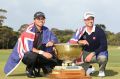 Jason Day and Adam Scott pose with the trophy after winning the teams event of the World Cup of Golf in 2013.