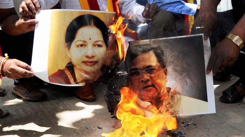 Pro-Kannada organisation activist burn posters of Tamil Nadu CM Jayalalithaa and Karnataka CM Siddaramaiah in protest against the Supreme Court verdict on Cauvery water, in Bengaluru. (Photo: PTI)