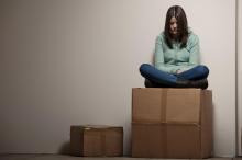 Teenage girl sitting on cardboard box