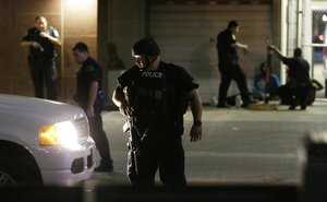 Dallas police detain a driver after a shooting in downtown Dallas, Thursday, July 7, 2016.