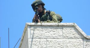 An Israeli soldier takes aim an internationals, in an effort to intimidate.