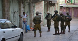 Israeli forces force Palestinian to lift up his shirt during a 'control'