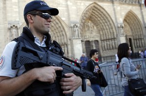 A French police officer patrols in front of Notre Dame cathedral, in Paris, Friday Sept. 9, 2016.