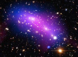 File - At first glance, this cosmic kaleidoscope of purple, blue and pink offers a strikingly beautiful — and serene — snapshot of the cosmos. However, this multi-colored haze actually marks the site of two colliding galaxy clusters, forming a single object known as MACS J0416.1-2403 (or MACS J0416 for short).