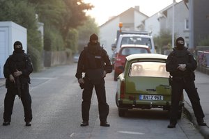 File - Special police officers secure a street near the house where a Syrian man lived before the explosion in Ansbach, southern Germany, Monday, July 25, 2016. Four attacks in a week — three of them carried out by asylum seekers — have left Germany on edge.