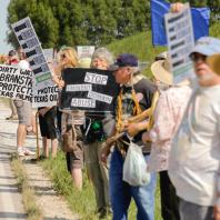 Protesters line the street as visitors to the Farm Progress Show stream past during a protest of the Dakota Access Pipeline at one of the entrances to a staging area used by Precision Pipeline, the builder of the oil pipeline, in Boone, Iowa, on Wednesday, Aug. 31, 2016. (Jim Slosiarek/The Gazette)
