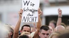 Ein Mann hält ein Plakat mit der Aufschrift " Wir schaffen das Nicht" bei einer Wahlkampfveranstaltung der CDU mit Kanzlerin Merkel hoch.