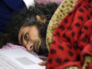 Former Guantanamo detainee Abu Wa'el Dhiab from Syria lies in bed as he speaks to his family through the computer in front of the press in his apartment in Montevideo, Uruguay,Friday, Sept. 9, 2016.