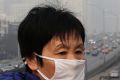 A woman wears a mask for protection against pollution as Beijing is shrouded in smog. 