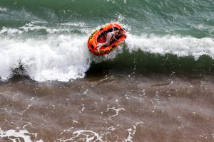 WEST BAY, ENGLAND - SEPTEMBER 01: A rubber dinghy is tossed by the waves as visitors take advantage of the fine weather ...