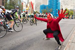 A fan dressed as the devil cheers for riders during the final stage of the Tour of Alberta cycling race, Monday, Sept. ...