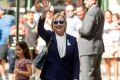 Hillary Clinton waves after leaving her daughter's apartment on Sunday following her early departure from the 9/11 ceremony.