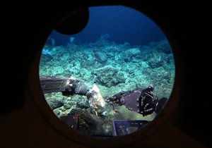 Robotic arms on the Pisces V submersible open a bag of bait on the Cook seamount during a manned dive to the previously unexplored underwater volcano off the coast of Hawaii's Big Island on Sept. 6, 2016.