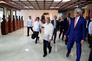 File - Philippines Foreign Secretary Perfecto Yasay points to the busts of his predecessors as he U.S. Secretary of State John Kerry walk through the Department of Foreign Affairs in Manila, Philippines, before a news conference that followed their bilateral meeting on July 27, 2016.