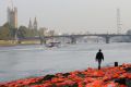 A man walks among hundreds of lifejackets scattered by UK charities ActionAid and Islamic Relief on the bank of the ...