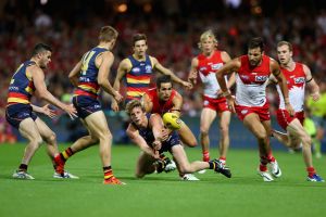 Adelaide’s Rory Sloane is tackled by Sydney’s Josh Kennedy during Saturday night’s semi-final at the SCG.