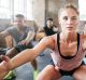 Shot of a group of people doing squats in a gym