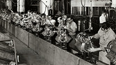 Photo of men working on an automobile engine assemly line. Undated photograph.