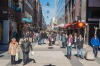 Shoppers and tourists strolling through the spring sunshine on the pedestrianised shopping street of Drottninggaten in ...