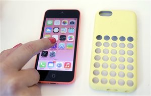 Members of the media review the new iPhone 5c during a new product announcement at Apple headquarters on Tuesday, Sept. 10, 2013, in Cupertino, Calif.