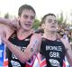 Britain's Alistair Brownlee, left, helps his brother Jonny to get to the finish line during the Triathlon World Series ...