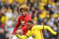 Hair-raising pace: Juan Camilo Zuniga of Watford races past Manchester United's Marouane Fellaini.